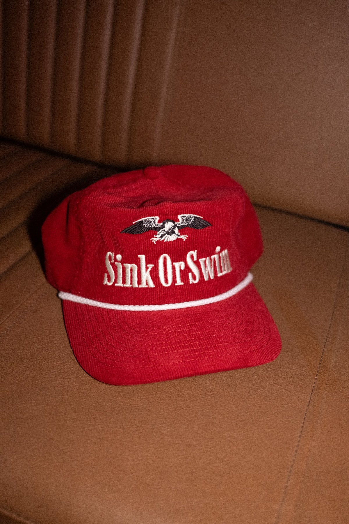 Red corduroy Vintage Eagle rope cap with cream Sink Or Swim script, embroidered eagle and white rope across the peak