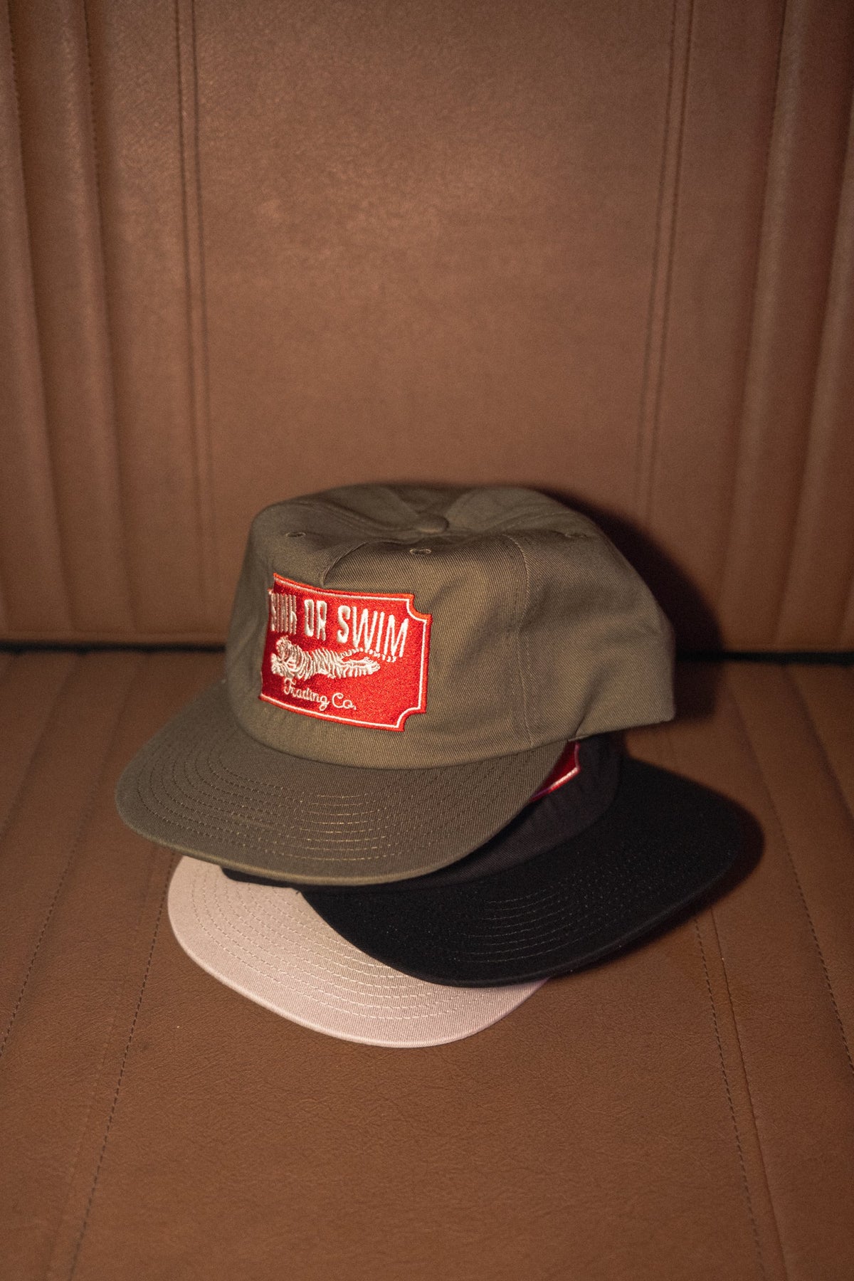 Vintage Tiger unstructured 5 panel caps stacked in army green, black and raw cotton canvas, each with a red tiger patch